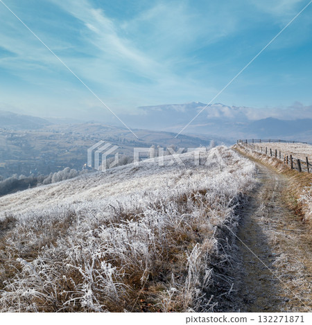 Winter coming. Last days of autumn, morning in mountain countryside peaceful picturesque hoarfrosted scene. Dirty road from hills to the village. Ukraine, Carpathian mountains. Winter coming. Last days of autumn, morning in mountain countryside peaceful picturesque hoarfrosted scene. Dirty road from hills to the village. Ukraine, Carpathian mountains. 132271871