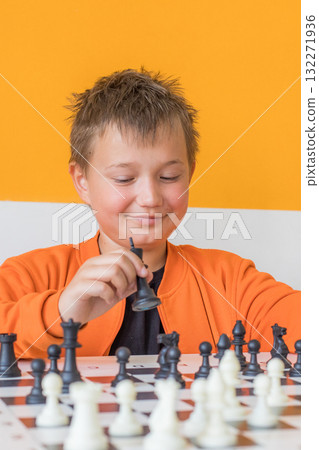 Happy school boy student playing chess in the classroom. Child with chess indoor 132271936
