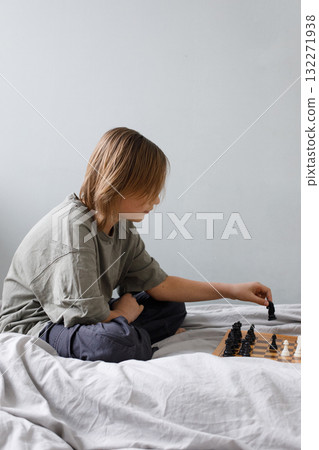 Smart child boy playing chess board game indoor. Kid 11 years old with chess at home Smart child boy playing chess board game indoor. Kid 11 years old with chess at home 132271938