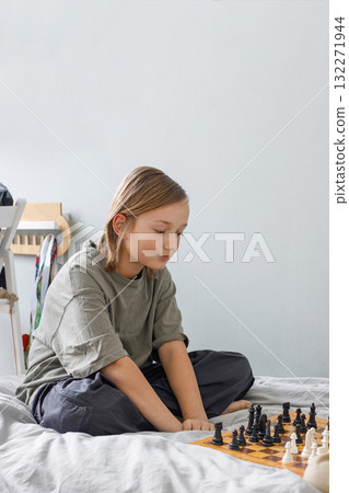 boy plays chess on the bed 132271944