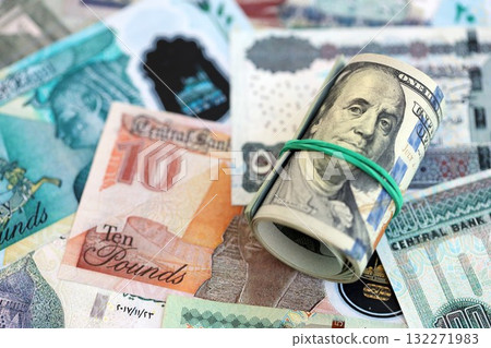 Egyptian pound currency money bills and bunch of us dollar banknotes close up. The concept of economics and currency exchange Egyptian pound currency money bills and bunch of us dollar banknotes close up. The concept of economics and currency exchange 132271983