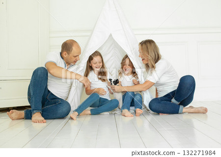 Cheerful family having fun with puppy dog pet at home 132271984
