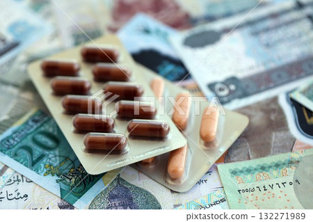Egyptian pound currency money bills and medicine pills close up. The concept of medicine and pharmacy Egyptian pound currency money bills and medicine pills close up. The concept of medicine and pharmacy 132271989