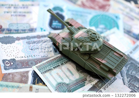 Egyptian pound currency money bills and toy tank close up. The concept of army funds and weapons sales Egyptian pound currency money bills and toy tank close up. The concept of army funds and weapons sales 132272006