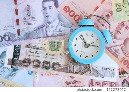 Thai baht currency money bills and alarm clock close up. The concept of time management and income Thai baht currency money bills and alarm clock close up. The concept of time management and income 132272052