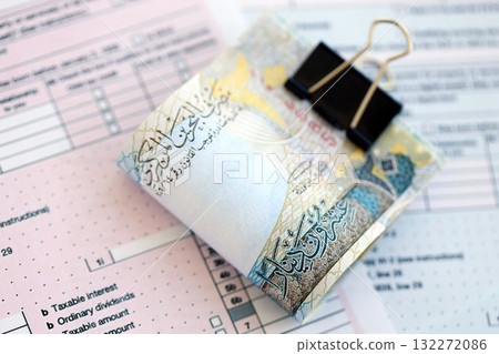 Bahraini dinar money bills on tax form close up. Taxation and accounting concept Bahraini dinar money bills on tax form close up. Taxation and accounting concept 132272086