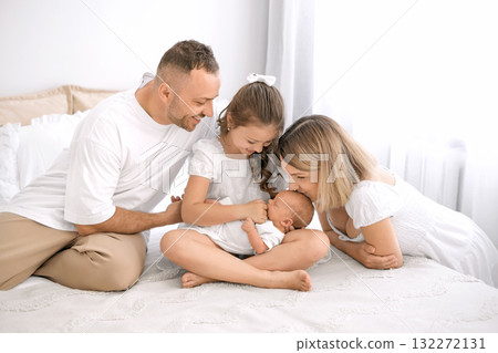 A newborn baby surrounded by the love of his parents and sister. Parenting and caring for children 132272131