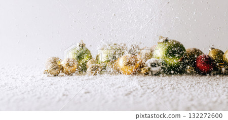 Christmas ornament artificial snow festive holiday decoration winter celebration glitter colorful cheerful sparkle seasonal joyful background white gold green red silver shiny ball hand sprinkle 132272600