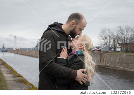 Romantic man and woman couple hugging each other kissing at seaside 132272986
