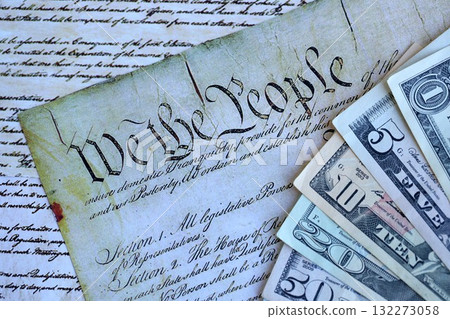 National Debt Ceiling Concept - US Constitution with different banknotes of Dollar Bills sitting above close up 132273058