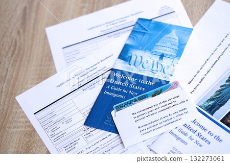 Permanent resident green card in envelope with application and guide for new immigrants lies on table close up 132273061