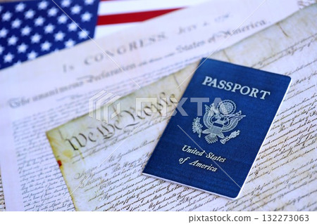Preamble to the Constitution of the United States with passport and American Flag. Old yellow paper with We The People text Preamble to the Constitution of the United States with passport and American Flag. Old yellow paper with We The People text 132273063