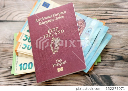 Ireland passport lies with euro money banknotes on wooden background close up. Cash and payments in Europe concept 132273071
