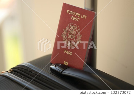 Estonia passport on touristic baggage luggage in airport close up. Travel and tourism in Europe concept Estonia passport on touristic baggage luggage in airport close up. Travel and tourism in Europe concept 132273072