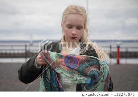 Attractive young woman with blond hair walking outdoors, portrait 132273075