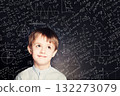 Thinking school child boy in classroom on chalkboard background. Education  concept 132273079