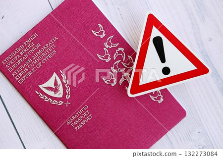 Kyprus passport with exclamation sign on white wooden background close up. Problems with citizenship in Europe concept 132273084