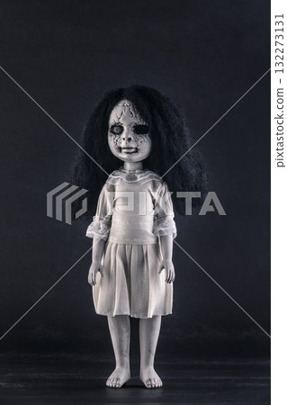 Scary cracked doll with black hair on dark background 132273131
