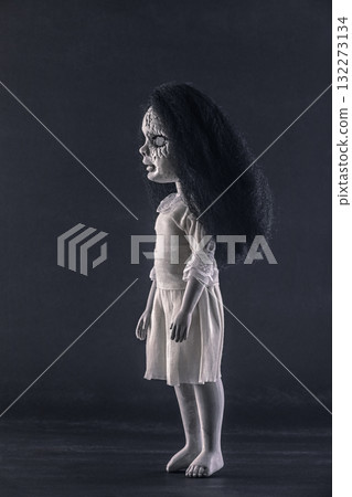 Scary cracked doll with black hair on dark background 132273134