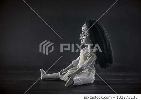Scary cracked doll with black hair on dark background Scary cracked doll with black hair on dark background 132273135