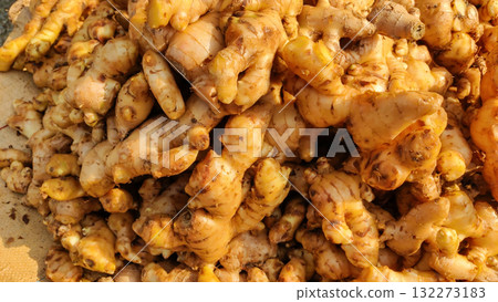 A closeup view of a large pile of fresh raw ginger roots highlighting their knobby texture and earthy brown color perfect for cooking and health benefits A closeup view of a large pile of fresh raw ginger roots highlighting their knobby texture and earthy brown color perfect for cooking and health benefits 132273183