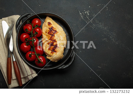 Grilled chicken breast fillet with cherry tomatoes in cast iron pan top view on rustic black background, healthy food, space for text Grilled chicken breast fillet with cherry tomatoes in cast iron pan top view on rustic black background, healthy food, space for text 132273232
