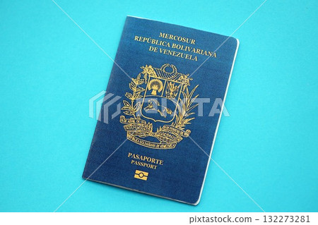 Venezuelan passport book on light blue paper background close up. Travel document on blue surface Venezuelan passport book on light blue paper background close up. Travel document on blue surface 132273281