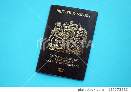 British passport book on light blue paper background close up. Travel document on blue surface 132273282