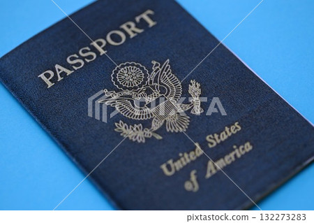 United States passport book on light blue paper background close up. Travel document on blue surface United States passport book on light blue paper background close up. Travel document on blue surface 132273283