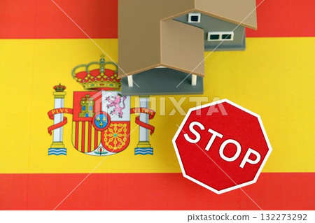 Residential house with stop sign on Spanish flag close up. Concept of Squatting in Spain. Okupas problem Residential house with stop sign on Spanish flag close up. Concept of Squatting in Spain. Okupas problem 132273292