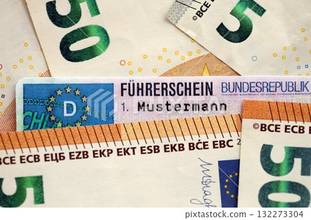 German driving license card called Fuhrerschein lies on big amount of Euro money close up 132273304