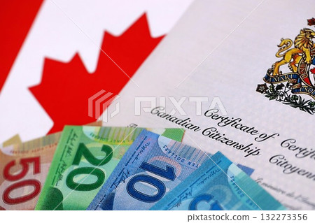 Canadian certificate of citizenship with money on Canadian flag close up 132273356