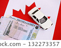 Canadian driving permit concept. Toy car and driver license on flag close up 132273357
