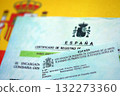 Citizenship or naturalization certificate document and card on flag of Spain close up 132273360
