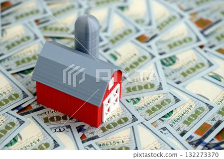 Old red american barn with silo on big amount of US dollar bills. Agriculture business concept close up Old red american barn with silo on big amount of US dollar bills. Agriculture business concept close up 132273370