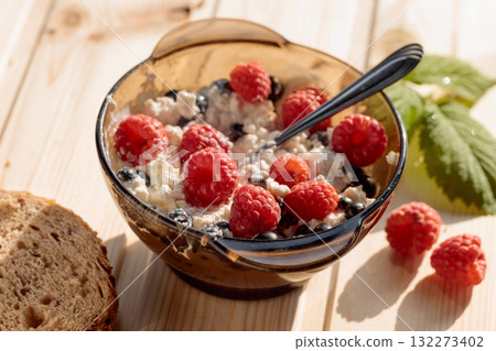 Cottage cheese with fresh raspberries and  blueberries. 132273402