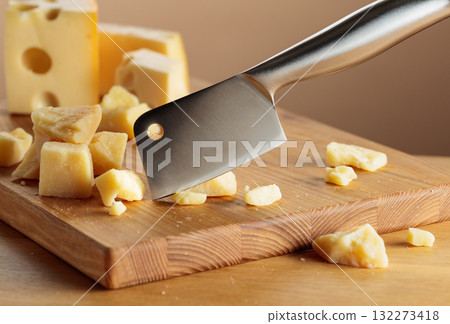 Parmesan cheese and knife on a cutting board. 132273418