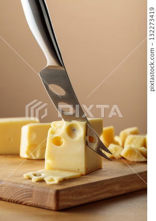 Cheese and knife on a wooden cutting board. Cheese and knife on a wooden cutting board. 132273419