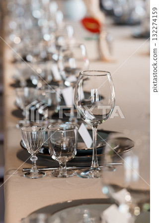 Elegant Wedding Table Setting with Crystal Glassware, Fine China, and Beige Linen. Luxurious Event Decor, Champagne Glasses, Formal Dinner Scene. 132274159
