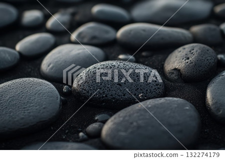 Black stones arranged outdoors, featuring distinct red marking on one stone. Soft natural lighting highlights textures and contrasts of surface. Neural network AI generated 132274179