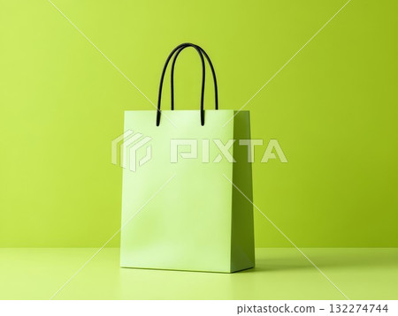 Empty green shopping bag against green background. Stylish design for eco or fashion themes, great for sustainable or chic ideas. Perfect for packaging or nature-inspired visuals. Empty green shopping bag against green background. Stylish design for eco or fashion themes, great for sustainable or chic ideas. Perfect for packaging or nature-inspired visuals. 132274744