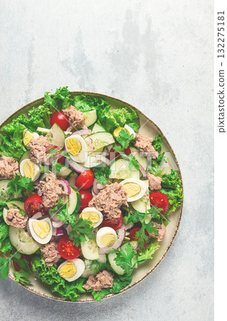 Tuna salad, vegetable salad with quail eggs, lettuce, red onion and cucumbers, on a light gray table, keto food, lifestyle, healthy eating, selective focus, top view, no people, 132275181