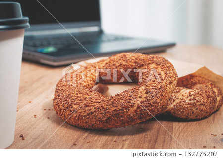 simits with coffee on a wooden table, with a laptop, in a cozy working environment, snack, breakfast, no people, 132275202