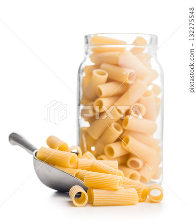 Uncooked rigatoni pasta in scoop isolated on white background. 132275548