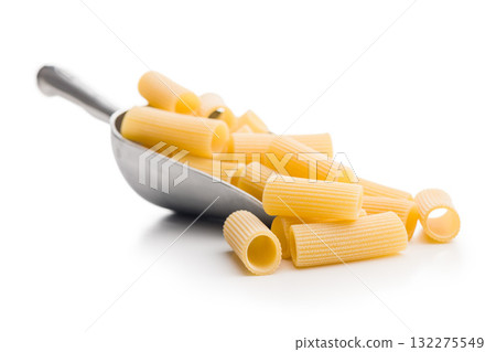 Uncooked rigatoni pasta in scoop isolated on white background. Uncooked rigatoni pasta in scoop isolated on white background. 132275549