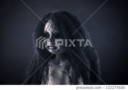 Portrait of a scary cracked doll with black hair on dark background Portrait of a scary cracked doll with black hair on dark background 132275680