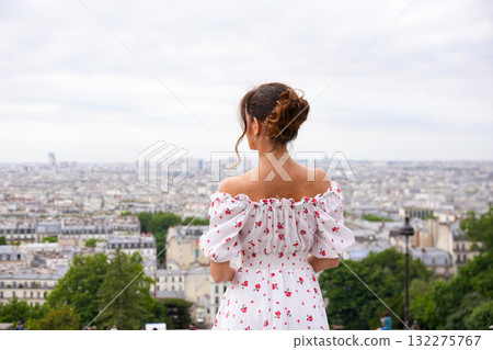 Young woman in floral dress admiring panoramic view of Paris 132275767