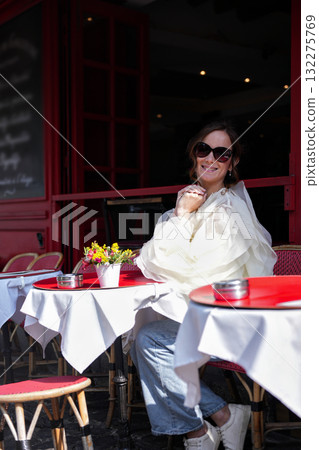 Woman sitting at Paris cafe terrace on sunny morning Woman sitting at Paris cafe terrace on sunny morning 132275769