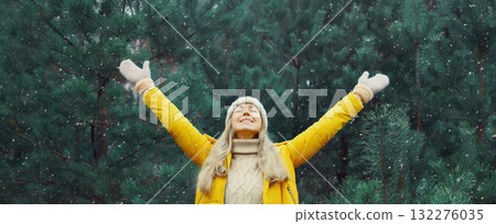 Winter day, happy smiling young woman enjoys snow, warm weather against Christmas tree Winter day, happy smiling young woman enjoys snow, warm weather against Christmas tree 132276035