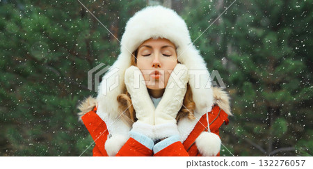 Winter portrait of happy smiling woman having fun in hat against Christmas tree in forest Winter portrait of happy smiling woman having fun in hat against Christmas tree in forest 132276057